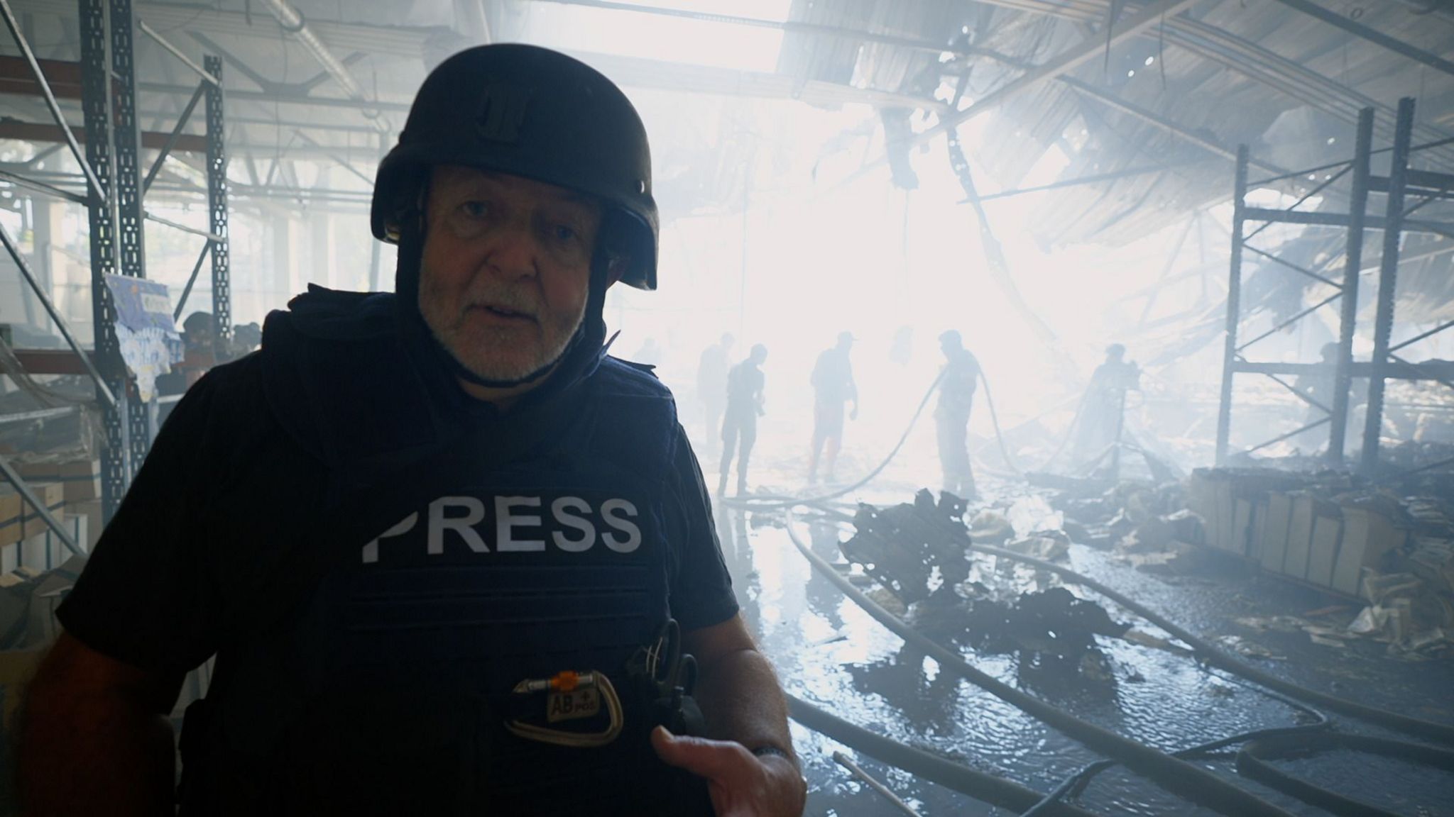 Jeremy Bowen stands inside burnt ruins of printing press