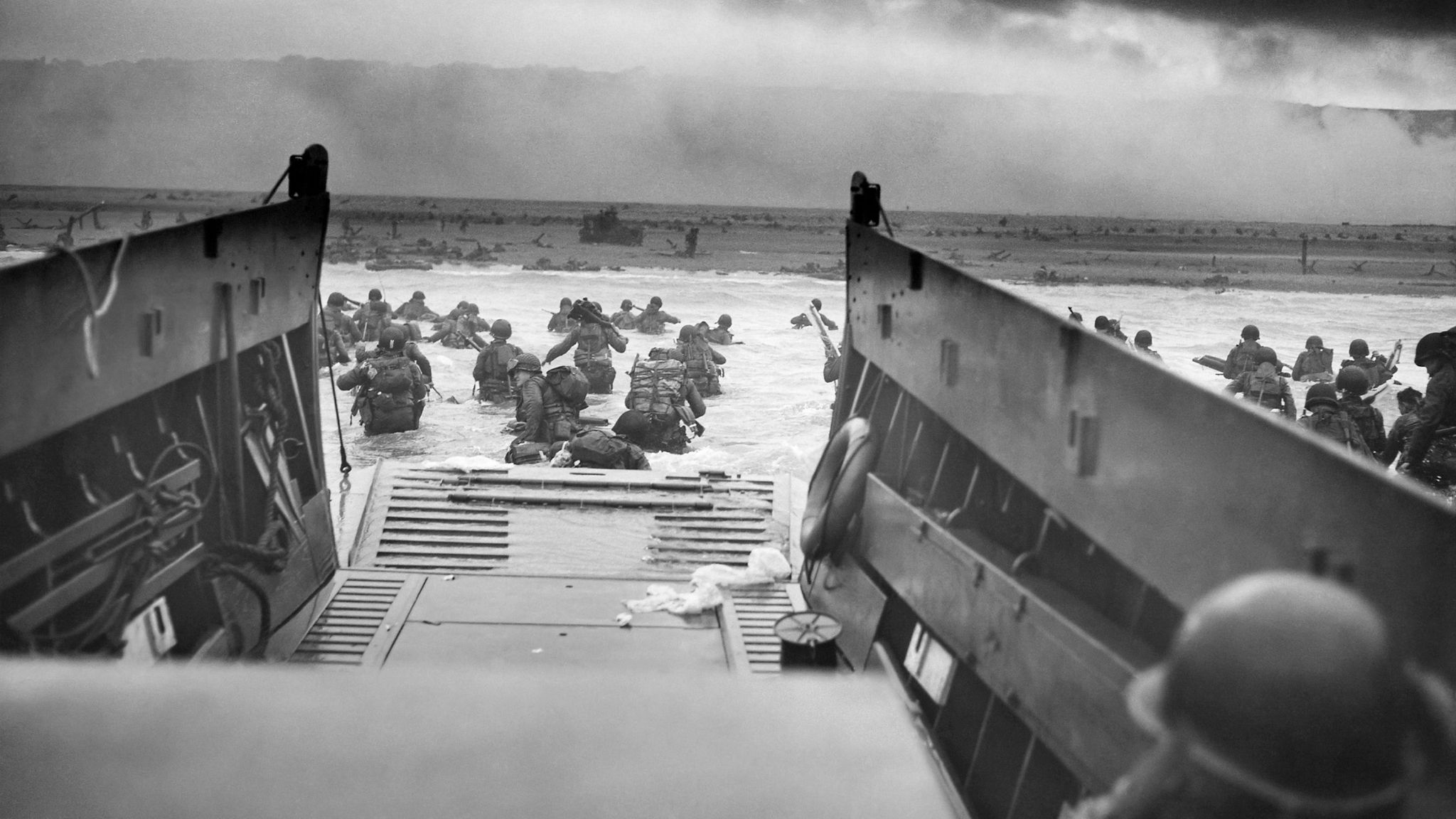 American troops disembarking from a landing craft onto Omaha beach