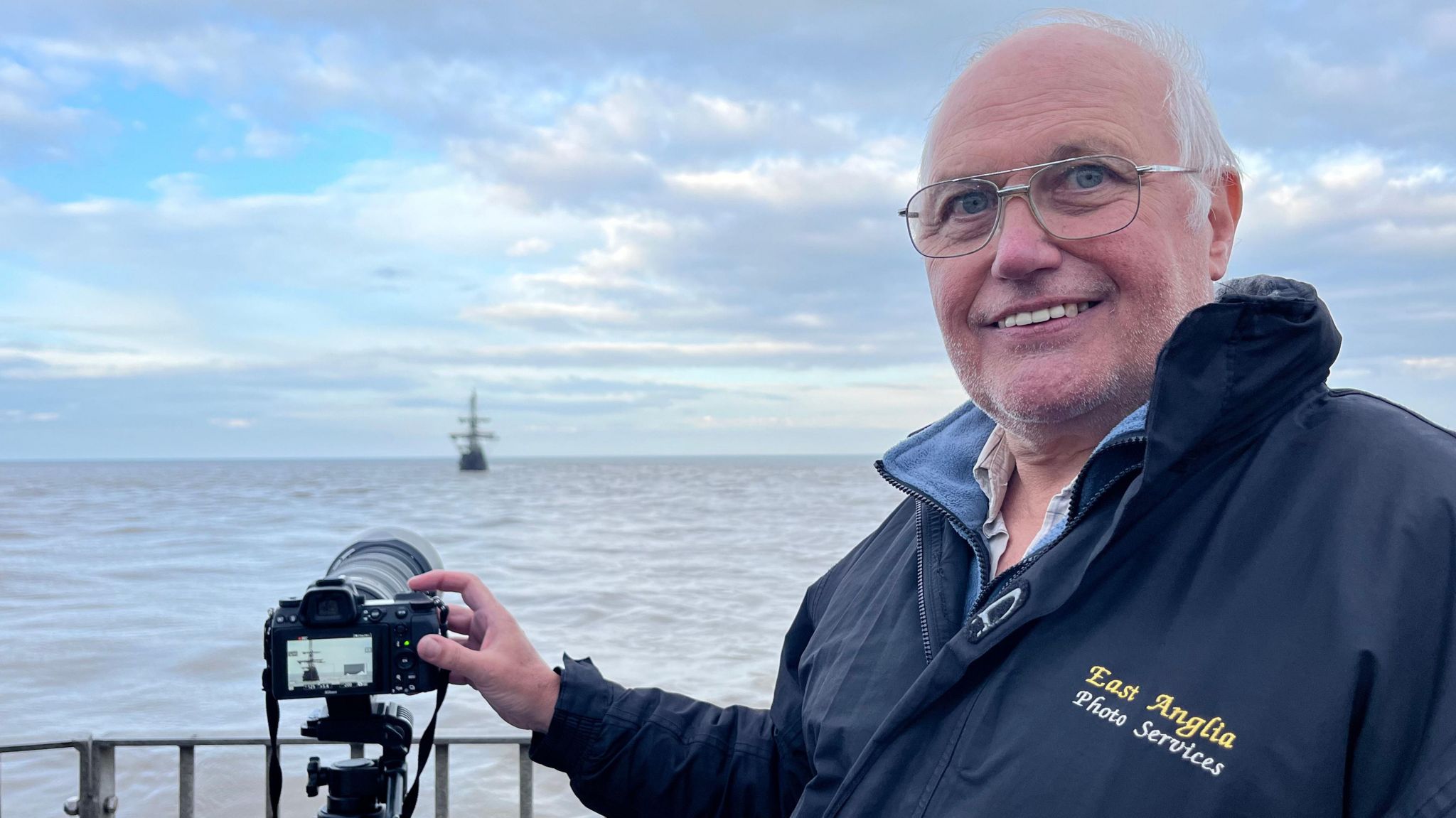 Barry Parsons smiling next to his camera 