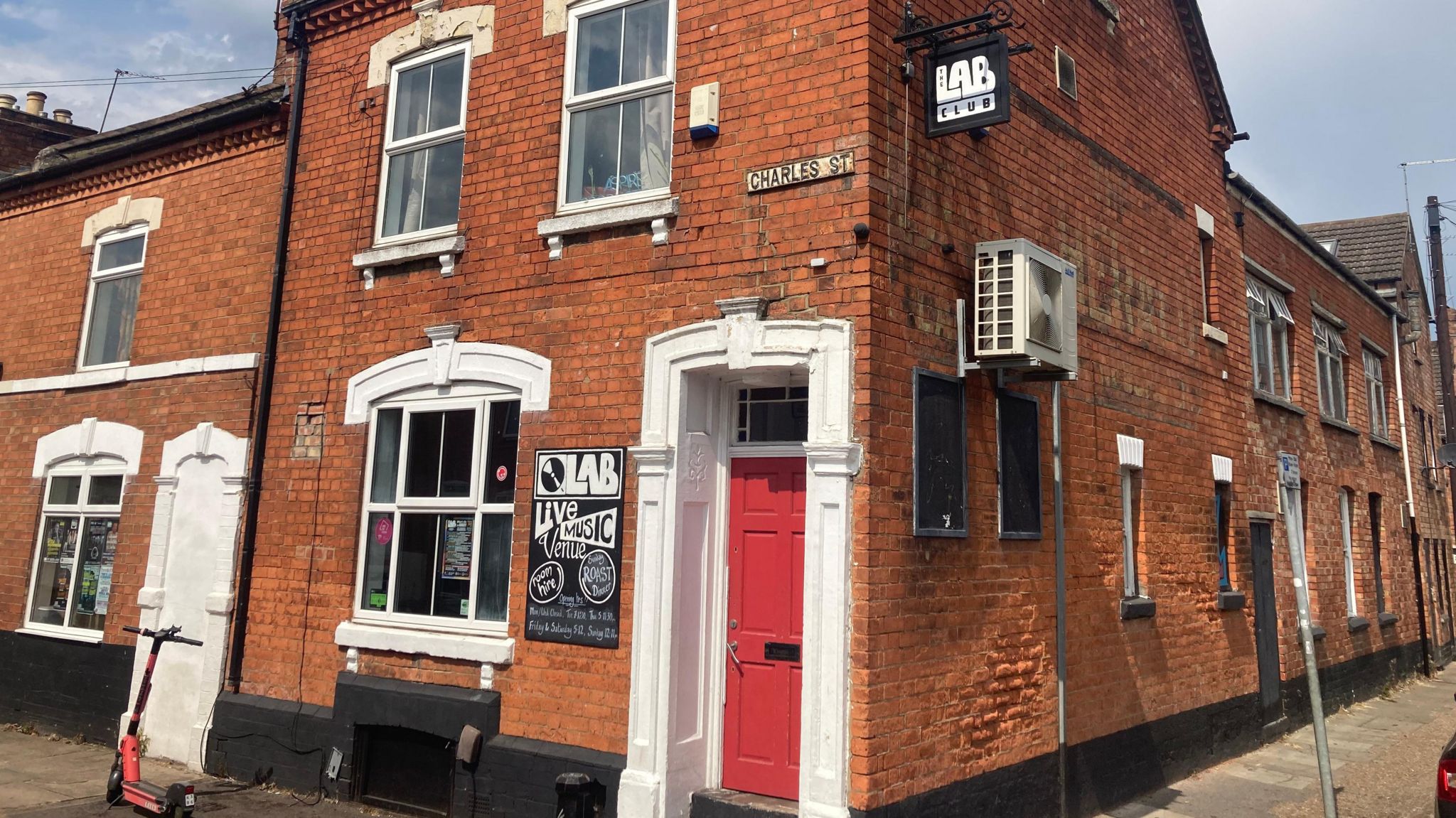 Brick-built row of terraced houses.  The end one has a "Lab" noticeboard.