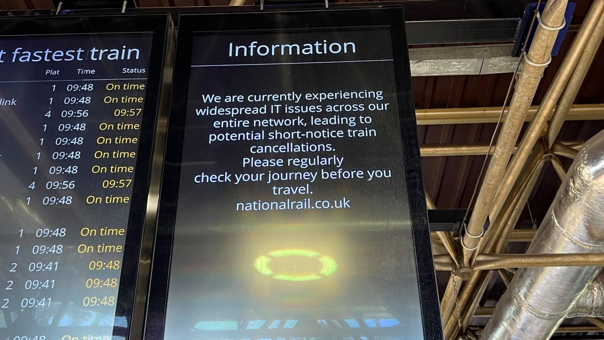 A screen at Bedford station warns about widespread IT issues