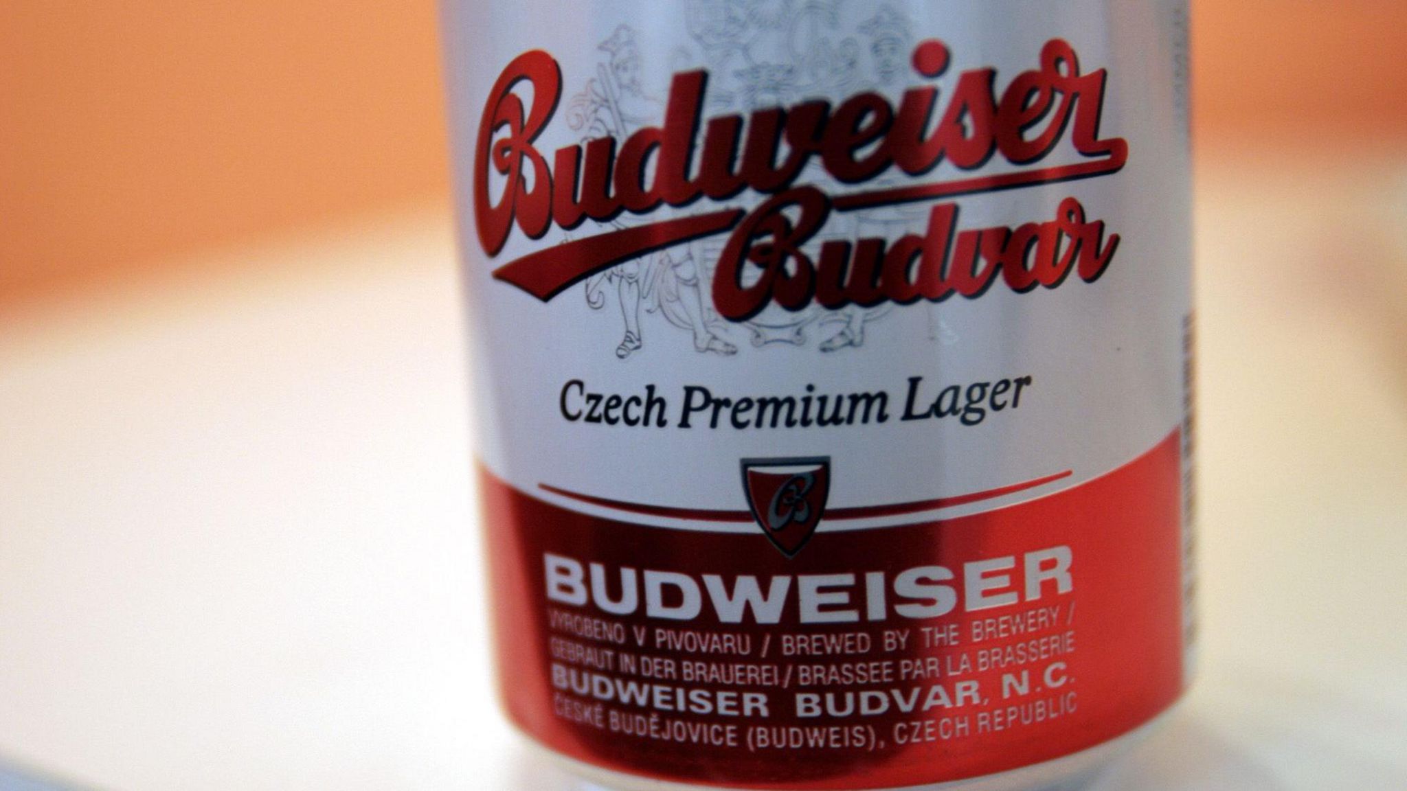 A red and white can of Budweiser Budvar lager. Picture shows half the can with writing on it. 