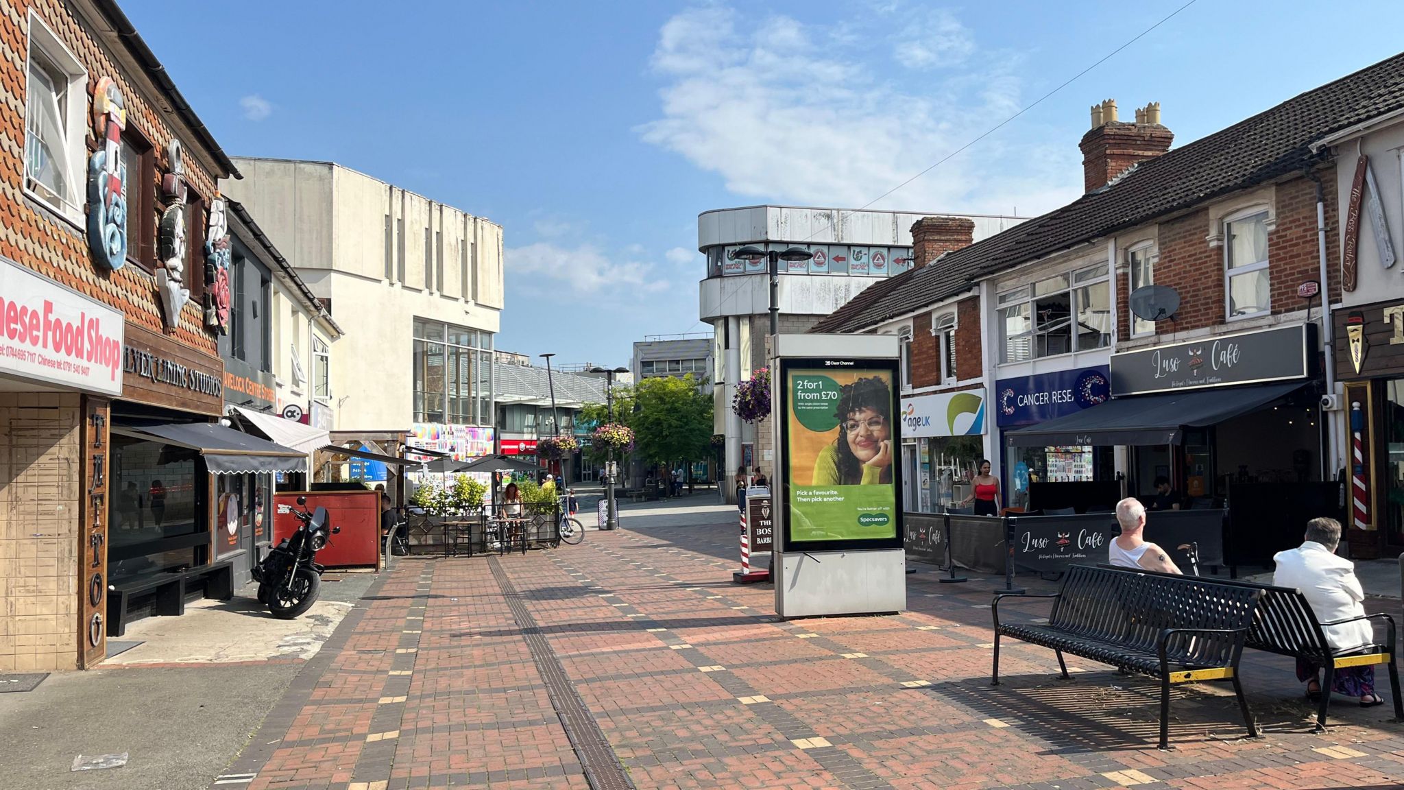 Havelock Street with some people sat on benches and small independent shops