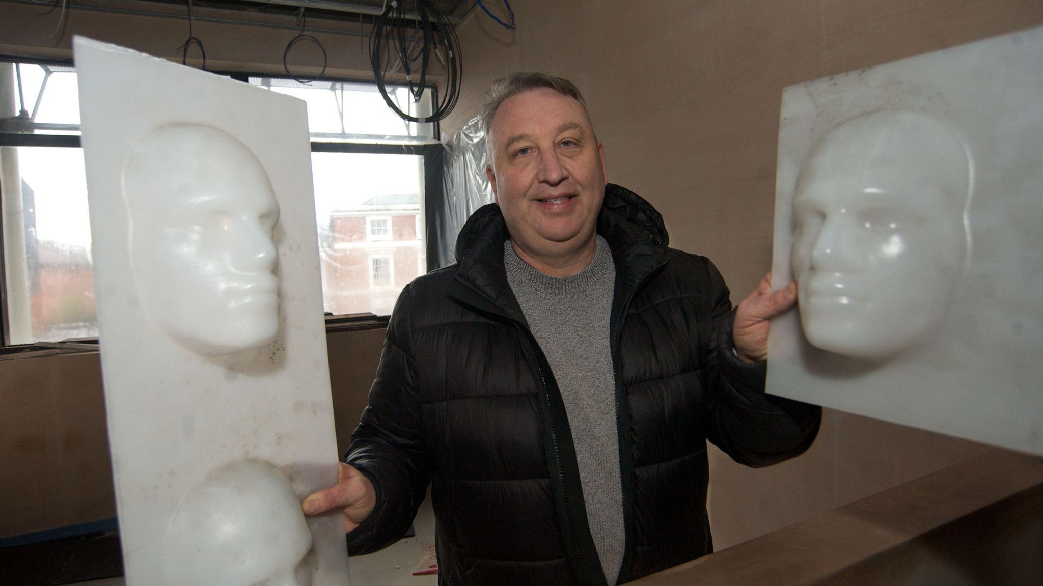 Snobs owner Wayne Tracey at the new site, holding some of the iconic ‘Snobs faces’ 