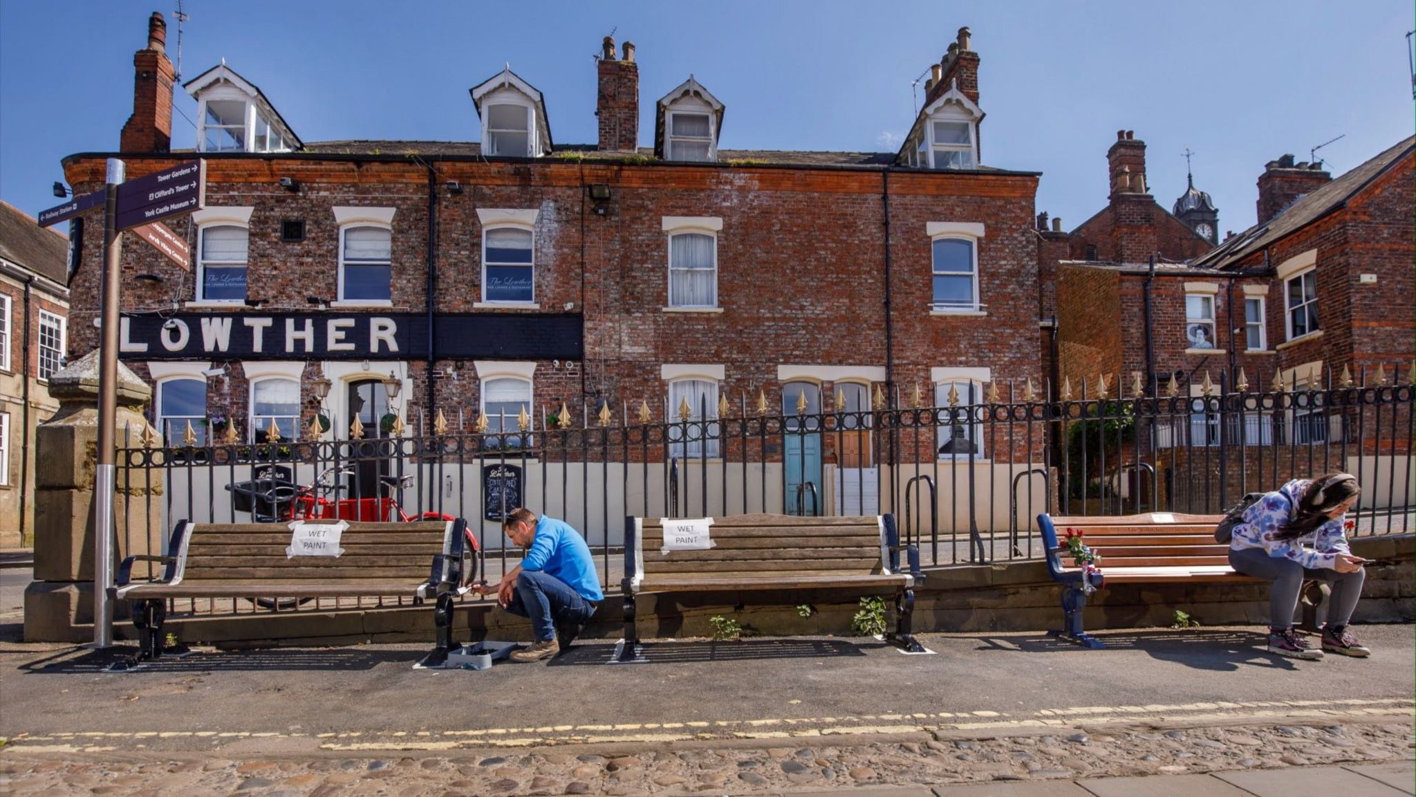 A volunteer painting a city bench.