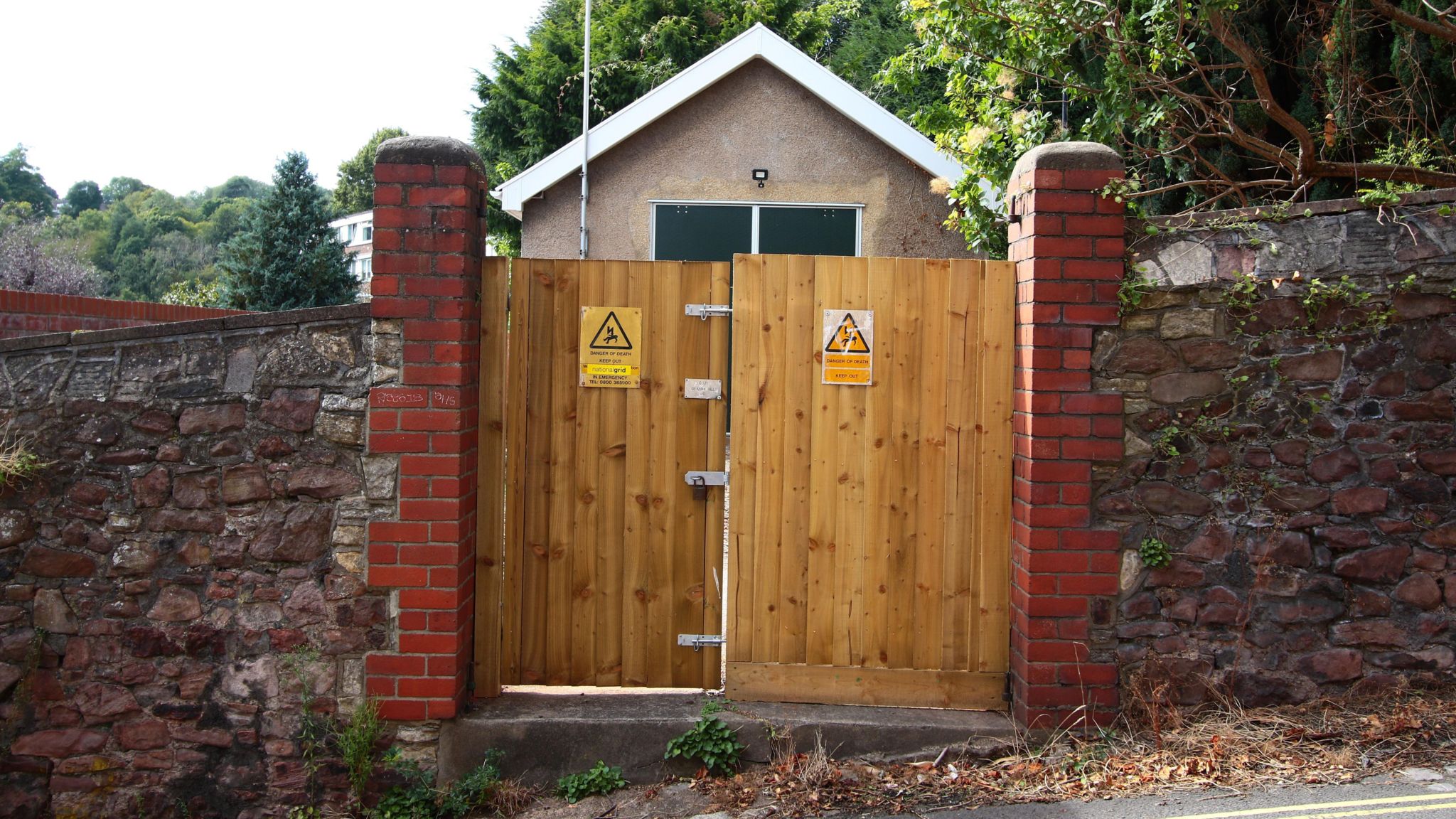 An electricity substation behind wooden locked doors on a street