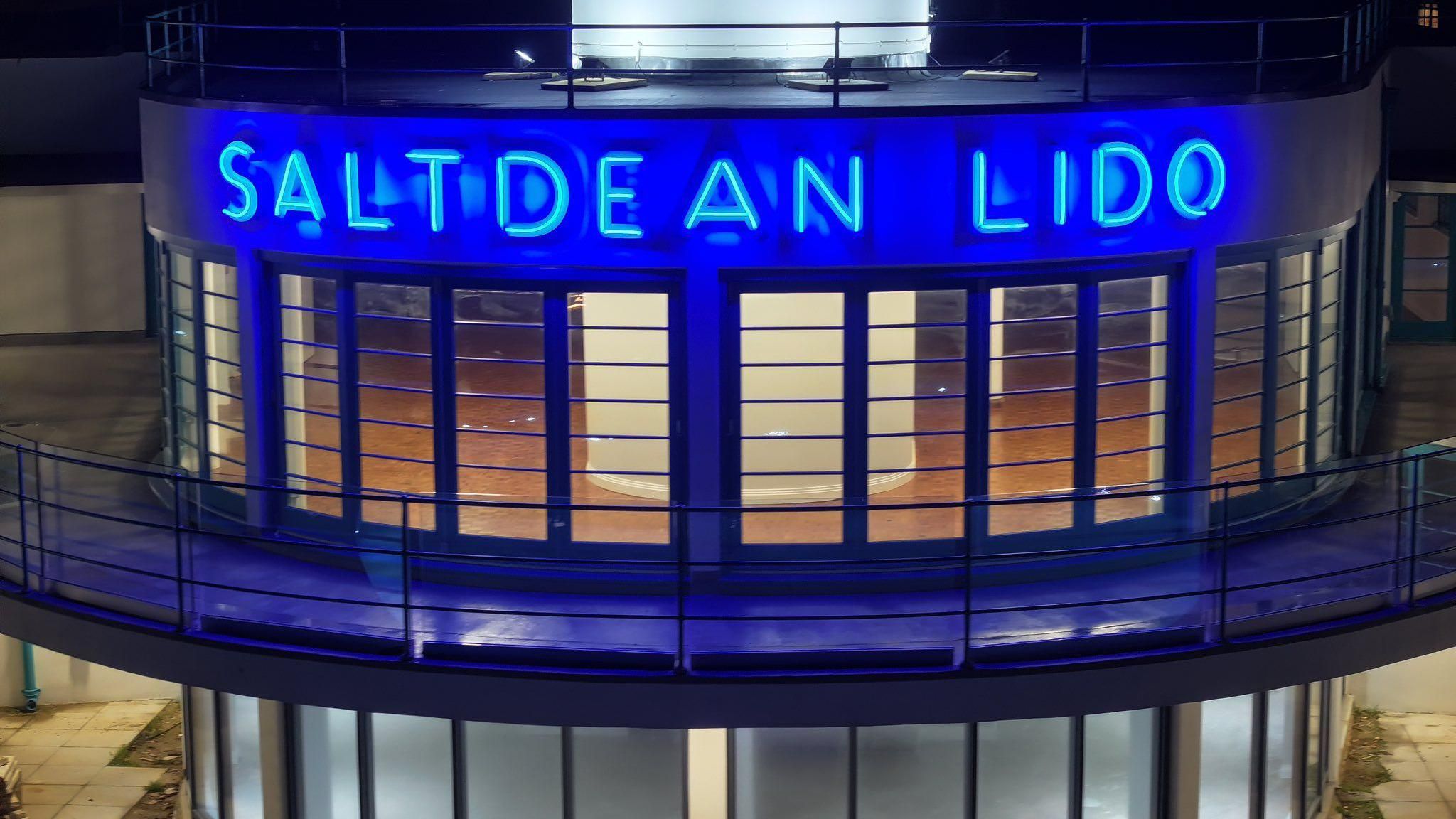 Blue neon sign which reads Saltdean Lido