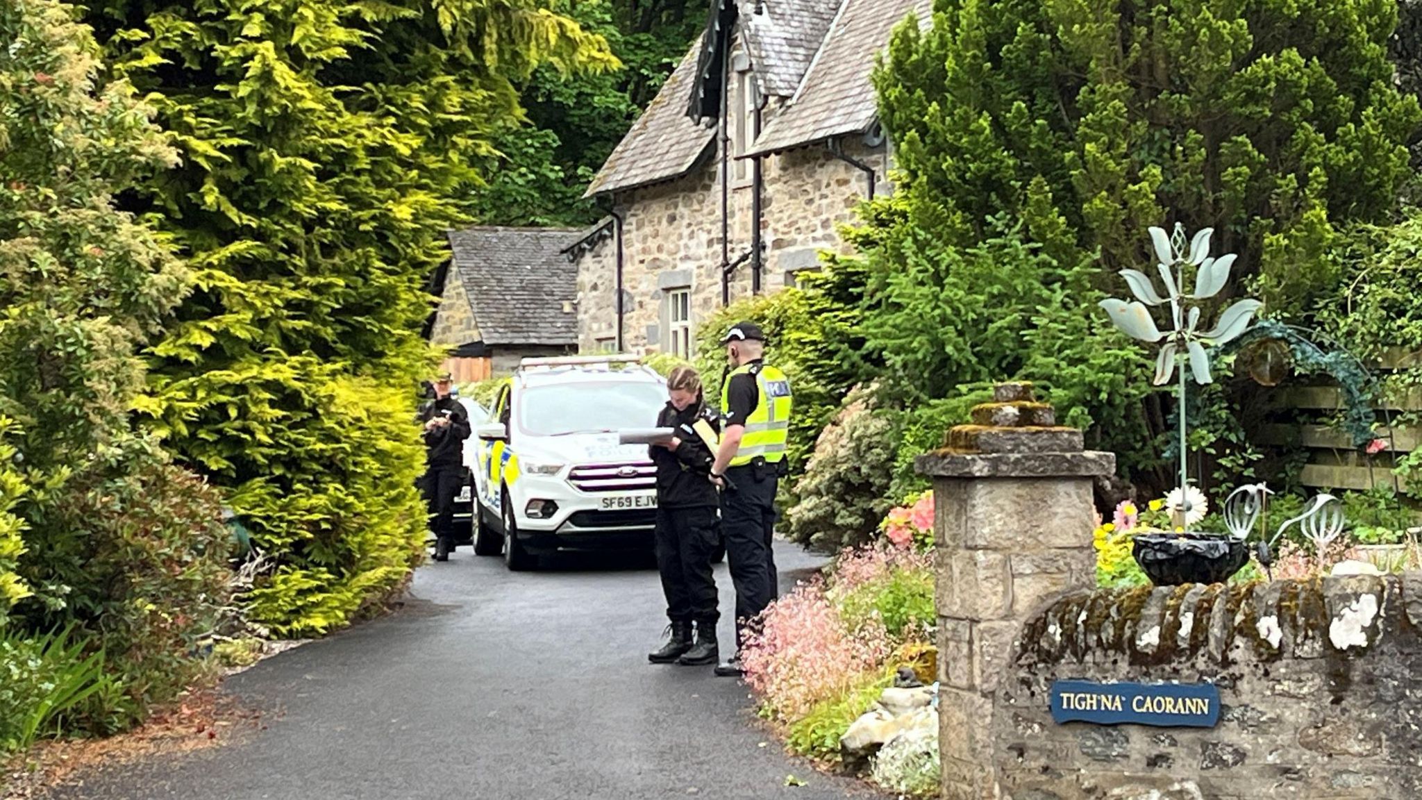 Police officers enter a home connected with the death of an Aberfeldy dog walker