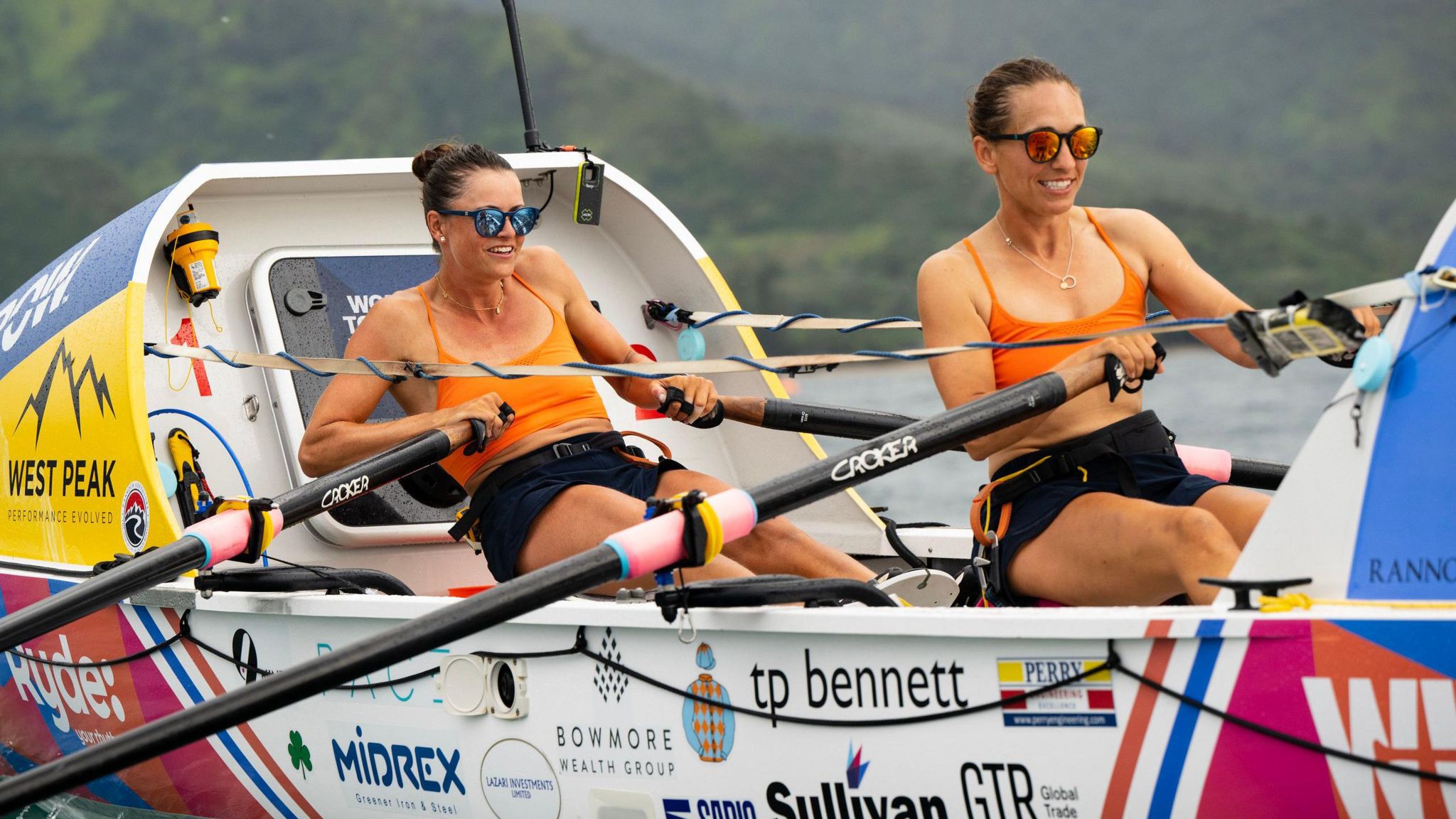 Jessica Oliver and Charlotte Harris smiling as they row across the finish line in Hawaii