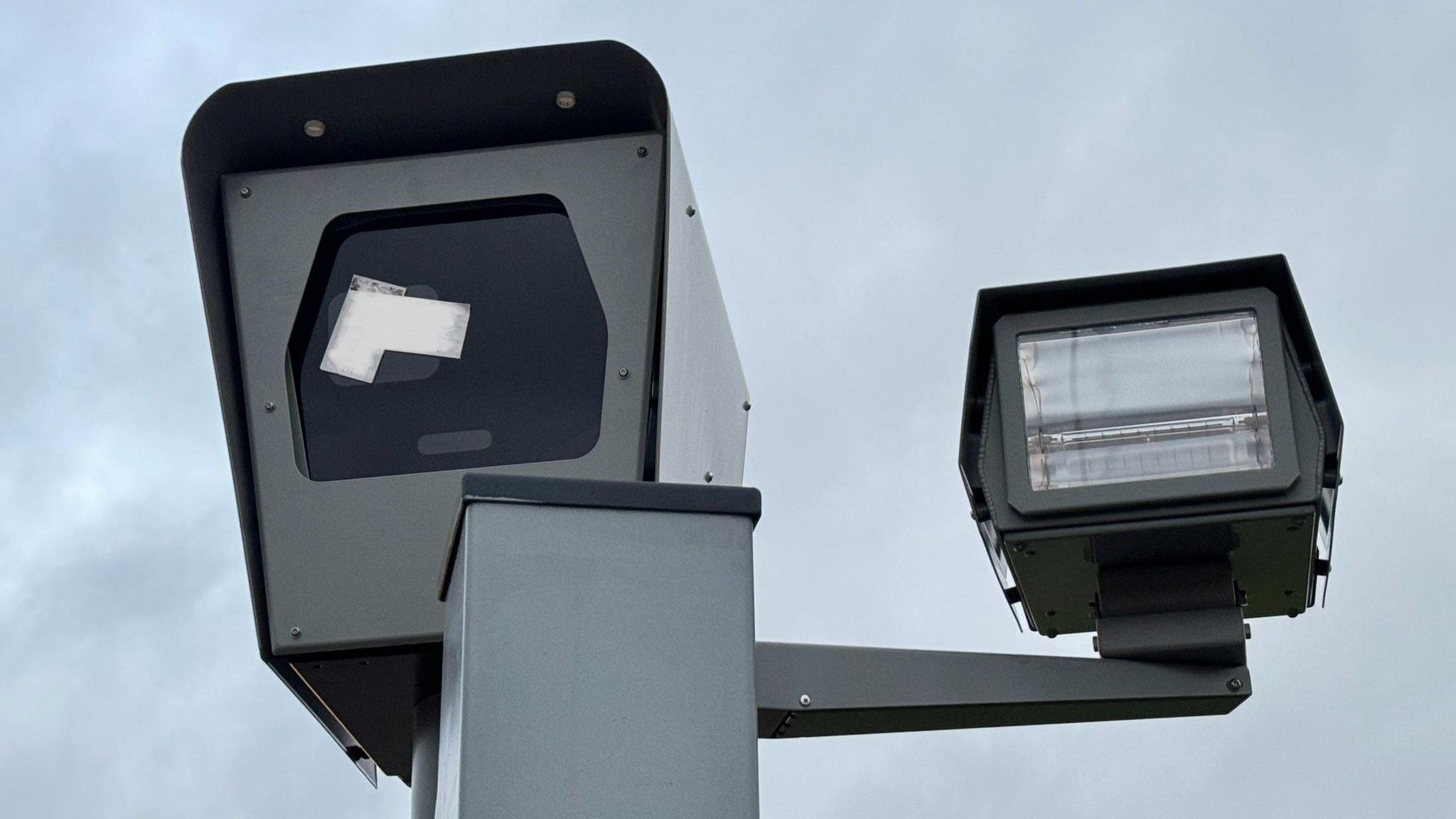 A speed camera with a sticker over the lens