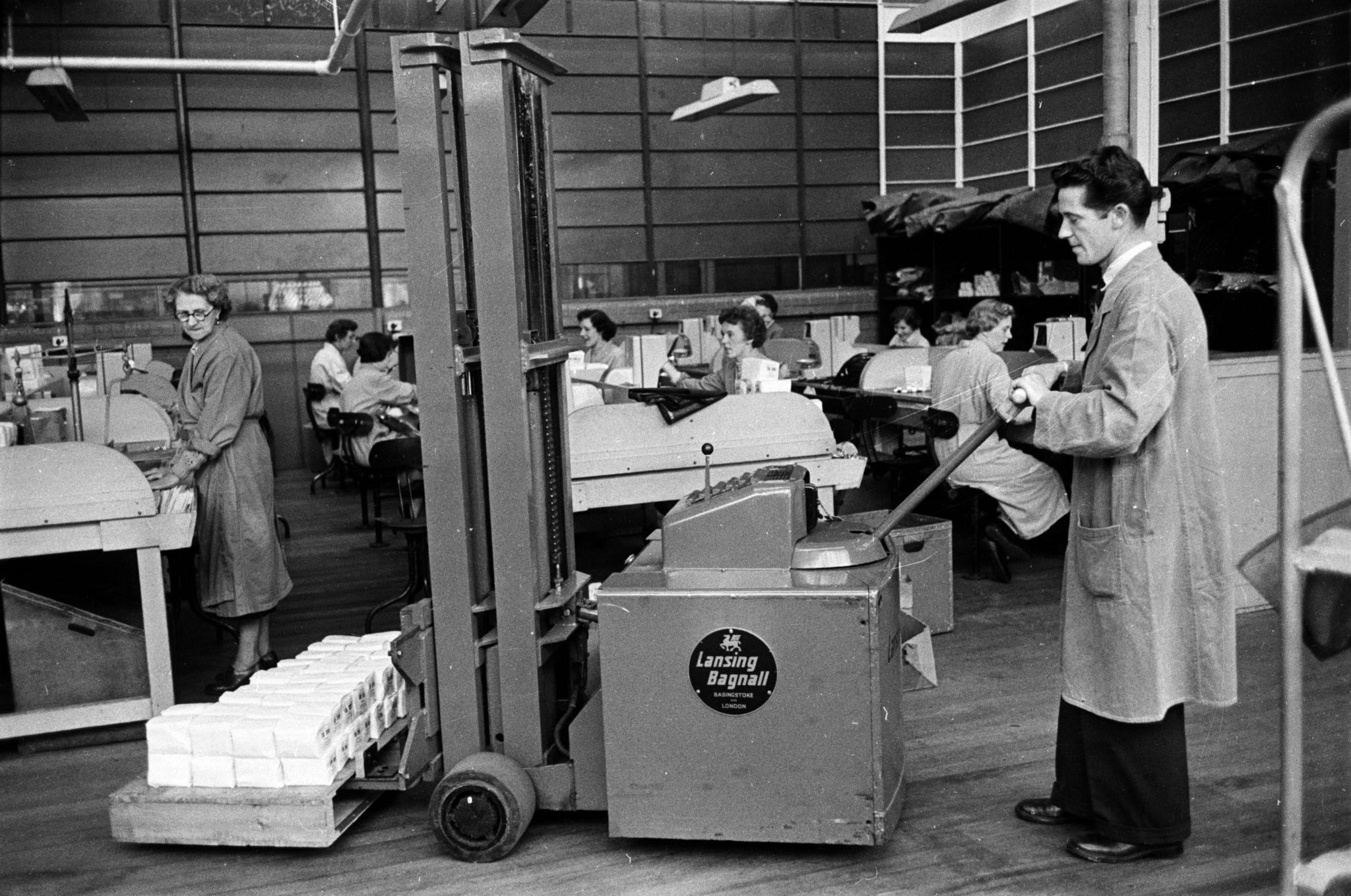 20th August 1955: A worker transports cartons of Three Nuns tobacco using a forklift vehicle at a factory in Glasgow. The tobacco industry in Glasgow dates back to the eighteenth century but it collapsed in the 1770s when the American War of Independence ruined the city's 'Tobacco Lords'. It was gradually rebuilt and local firm Stephen Mitchell & Son still operates from Alexander Parade which is the oldest foundation of the tobacco trade, dating back to 1723. Original Publication: Picture Post - 7942 - Let Glasgow Flourish! - pub. 1955 (Photo by Haywood Magee/Picture Post/Hulton Archive/Getty Images)