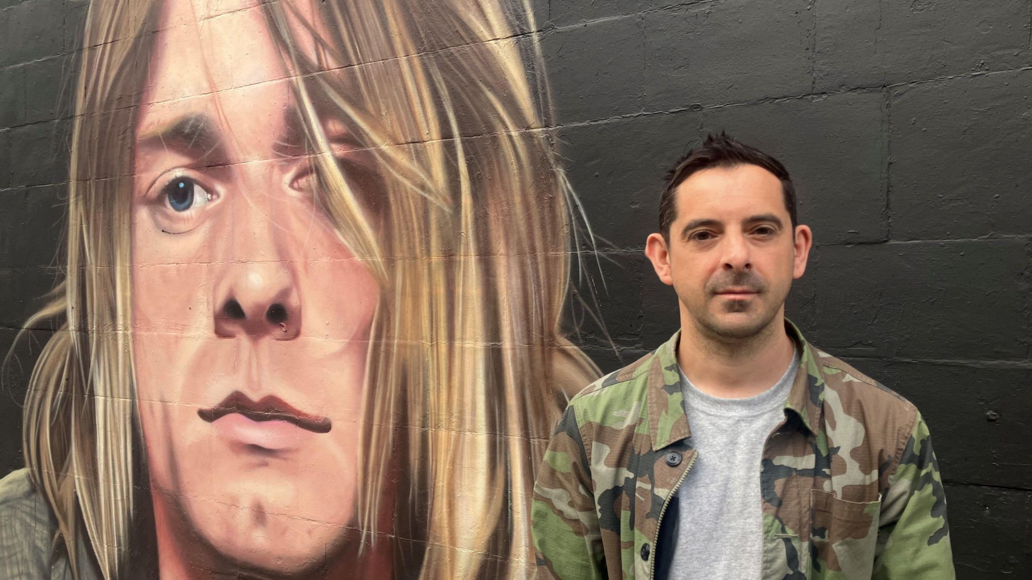 Atheer Al-Salim stood next to a mural of Kurt Cobain