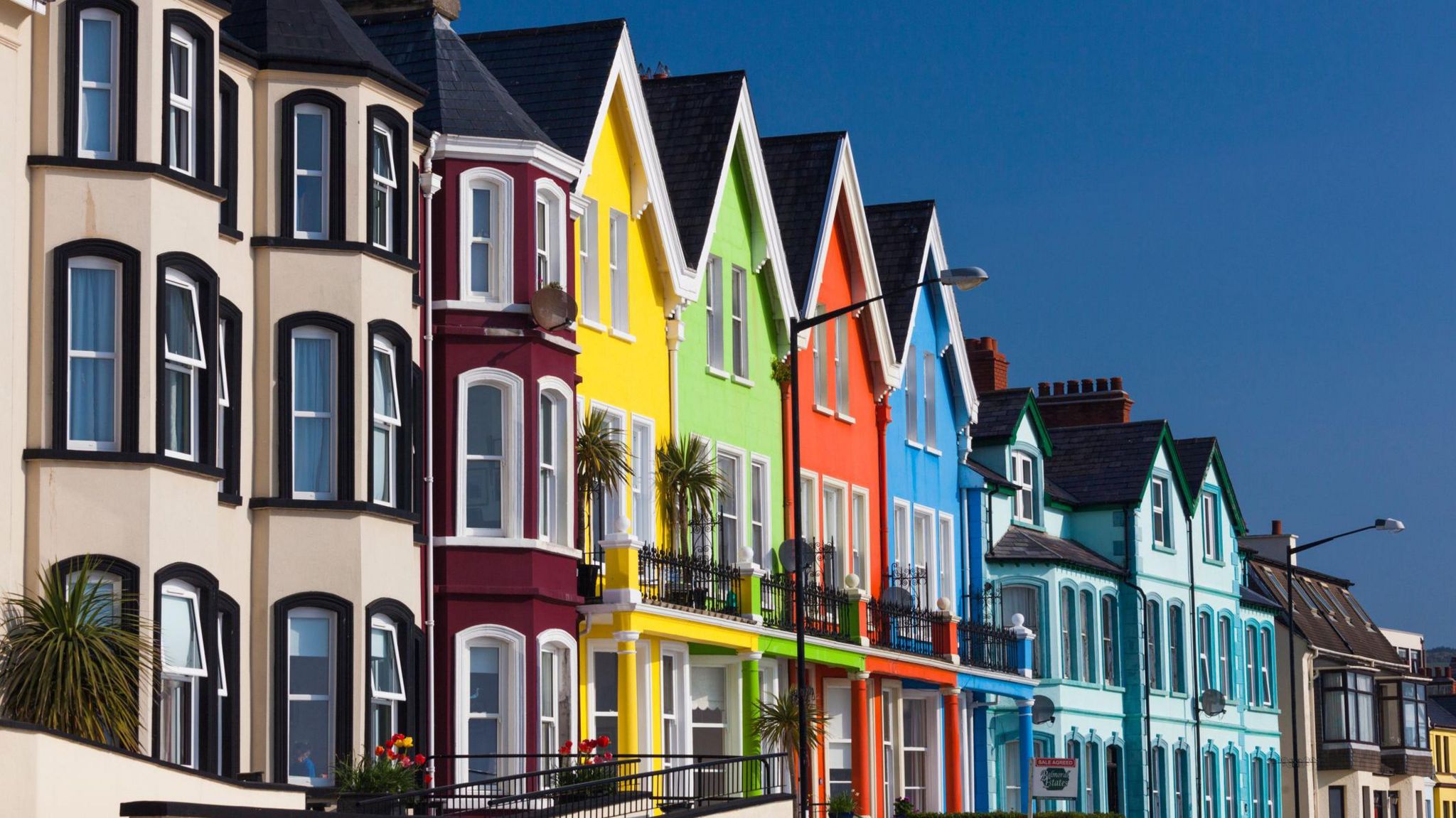 A row of colourful attached houses under a blue sky