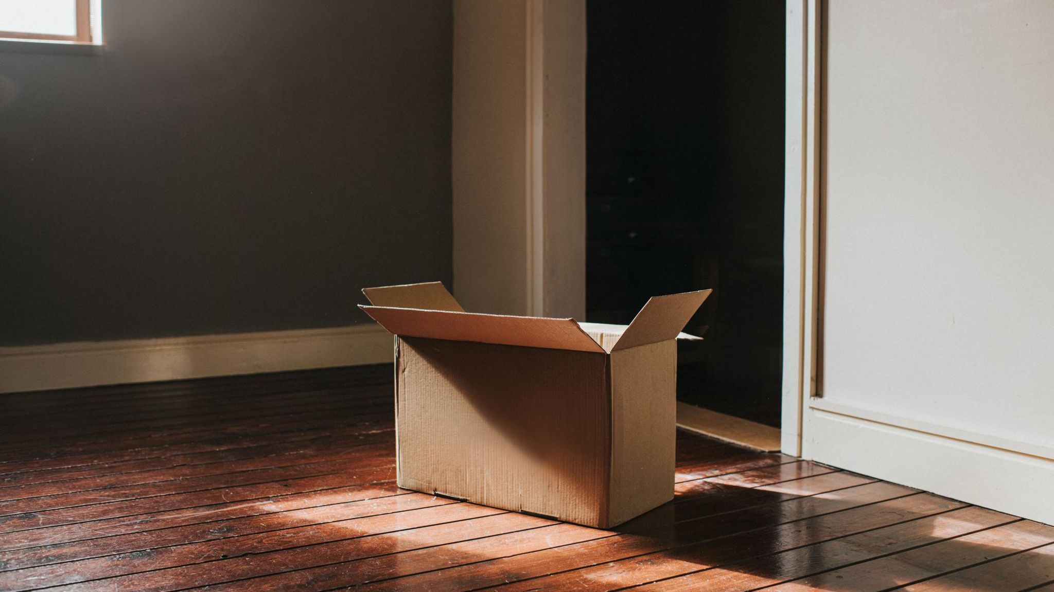 A cardboard moving box on the floor of an empty room