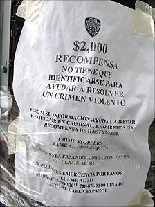 A sign offers a reward for help solving a violent crime