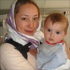 Karen Woo holding a baby at The French Medical Institute for Children in Kabul
