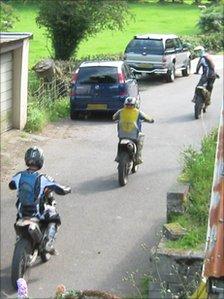 Off-road motorbikes being ridden in a lane
