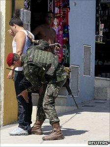 Soldier frisks a man in Complexo do Alemao on 29 November