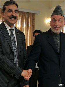 Afghanistan's President Hamid Karzai (r)shakes hands with Pakistani Prime Minister Yousuf Raza Gilani, 4 december 2010