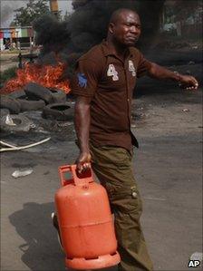 Man carrying bottle of cooking gas