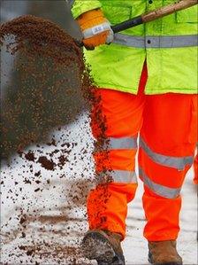 A council worker spreading road salt
