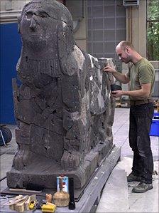 Restorer using glue to stick the statue together