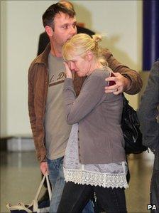 A woman is emotional as her husband arrives on a flight from Tripoli that was chartered by oil companies