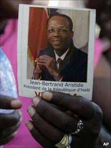 Woman holds photograph of Jean-Betrand Aristide on 11 March 2011