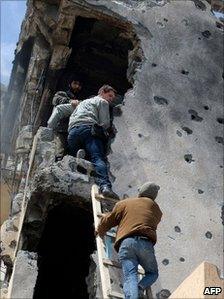 Tim Hetherington (centre) is assisted by Libyan rebels as he climbs down a building in Misrata on 20 April 2011