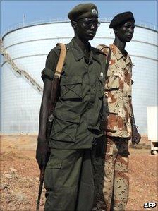 Southern Sudanese soldiers standing next to crude oil reservoir tanks at a field processing facility in Unity State (Archive shot November 2010)