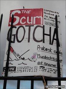 A mocked-up front page of The Scum newspaper is placed on railings outside the offices of the News of the World (9 July 2011)
