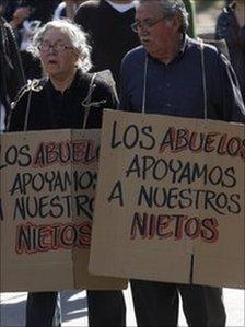 A man and a woman demonstrate in support of Chile's students holding signs that read in Spanish "Grandparents support their grandchildren" in Santiago, Tuesday, 9 August 2011