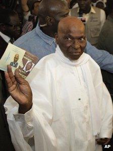 President Abdoulaye Wade holds up the ballot papers for himself and opponent Macky Sall