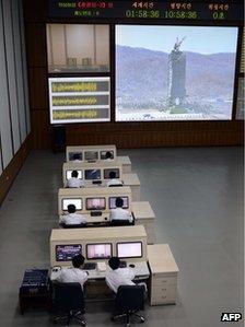 North Korean technicians watch live images of the rocket Unah-3 at the satellite control room of the space centre on the outskirts of Pyongyang (April 11, 2012)