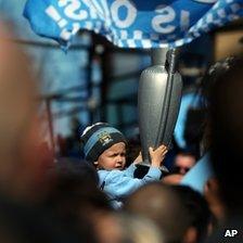 Boy with inflatable trophy at Manchester City parade