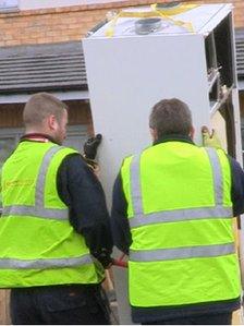 Builders removing the heating system on a housing estate in Runcorn.