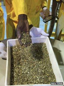 A worker holds gold pieces during the inauguration of the Sudan Gold Refinery in Khartoum on 19 September 2012