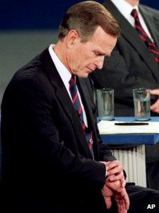 George H W Bush looks at his watch during a 1992 presidential debate