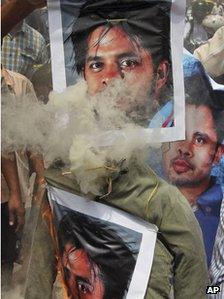 На этой фотографии, сделанной в четверг, 16 мая 2013 года, индийцы сжигают чучело с плакатами индийского игрока в крикет Шантакумарана Шрисанта в знак протеста против фиксирования точек во время Индийской премьер-лиги (IPL) в Бангалоре, Индия. А