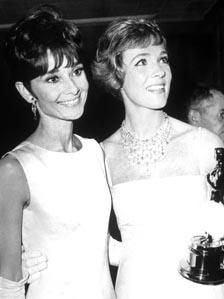 Julie Andrews (right) holds her Oscar while standing with Audrey Hepburn