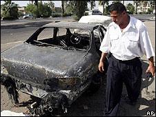 Iraqi security guard looks at car hit in the Nissor square shootings of September 2007
