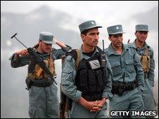 Afghan policemen gather near the area where a plane is believed to have crashed, on May 17, 2010
