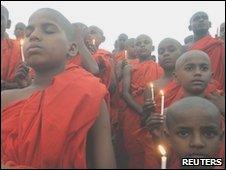 Buddhist monks attend a candlelight prayer ceremony for the victims of the crashed Air India Express passenger plane, in the central Indian city of Bhopal