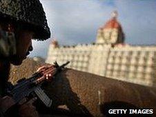 An Indian soldier surveys the Taj Mahal Palace Tower Hotel in Mumbai, during the attack in November