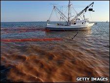 A shrimp boat collects oil with booms off Louisiana, 5 May