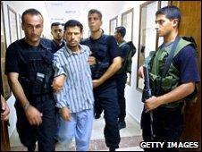 An alleged collaborator is arrested by Hamas police in Gaza