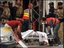 Rescuers remove a body from a mosque in Lahore, 28 May