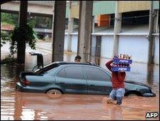 Man carries bottles through flood in Guatemala