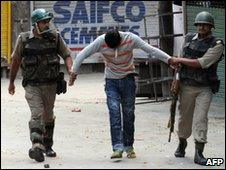 Indian paramilitary soldiers detain a Kashmiri youth in Srinagar