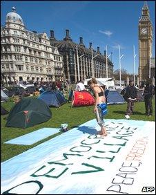 A woman paints a banner in the "Democracy Village" in Parliament Square